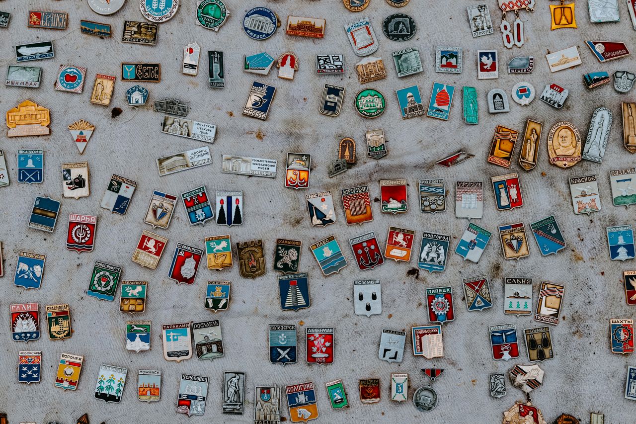 A colorful assortment of vintage enamel pins displayed on a fabric surface.