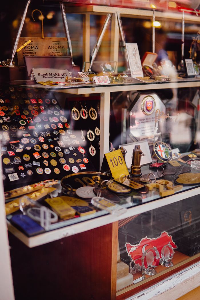 A diverse array of vintage pins, badges, and collectible items on display in a store window.