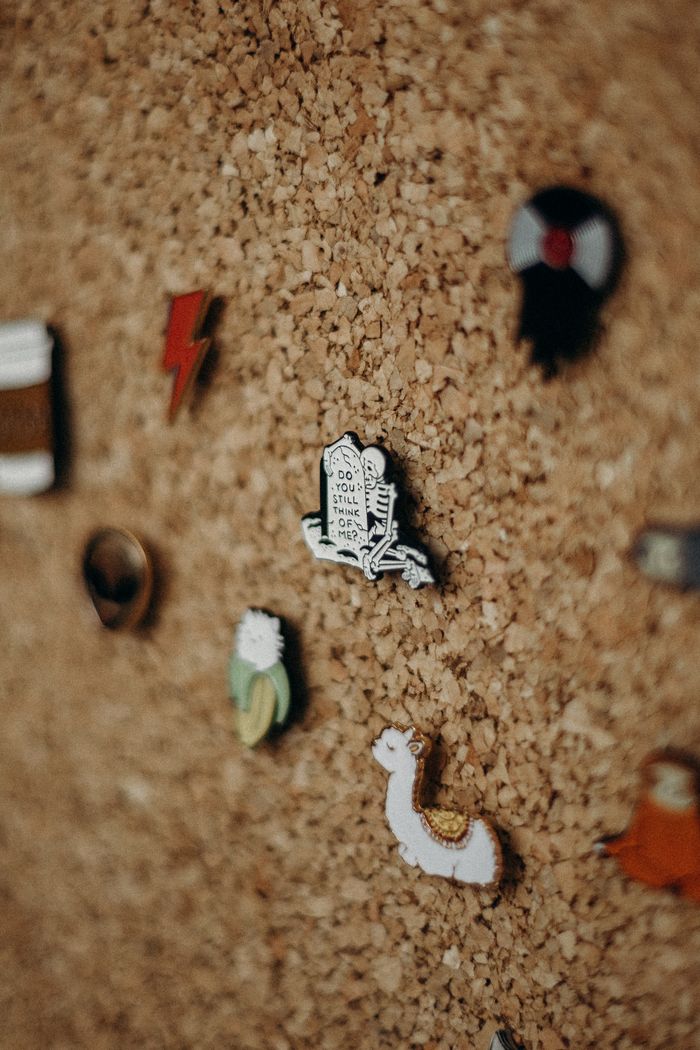 Close-up of various creative pins on a cork board, showcasing a unique textured display.